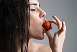 Woman biting strawberry.