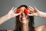 Woman with tomatoes covering eyes.