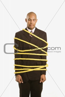 Businessman tied in rope.