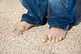 Male feet on beach.