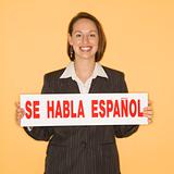 Businesswoman holding bilingual sign.