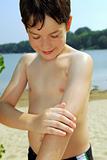 Boy applying sunscreen