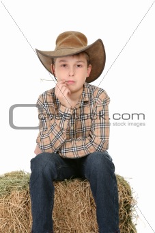 Cowboy sitting on hay bale