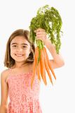 Girl holding carrots.