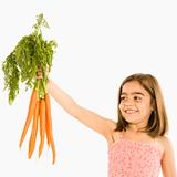 Girl holding carrots.