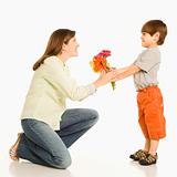 Boy giving mother flowers.