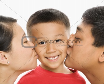 Parents kissing son.
