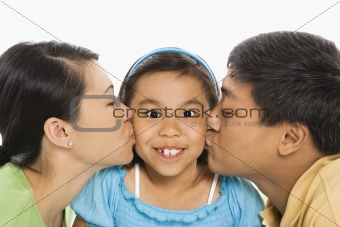 Parents kissing daughter.