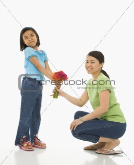 Daughter giving mother flowers.