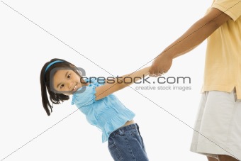 Girl holding father's hands.
