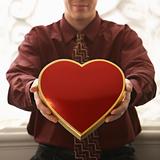 Man holding heart shaped box.