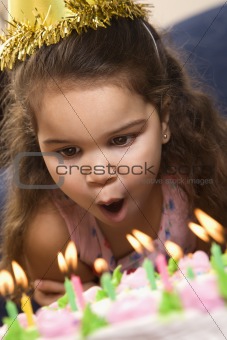 Girl blowing out birthday candles.