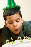 Boy blowing out birthday candles.