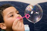 Boy blowing soap bubble.