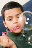 Boy blowing soap bubbles.