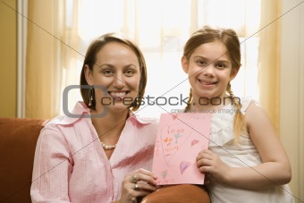 Girl giving mom a drawing.