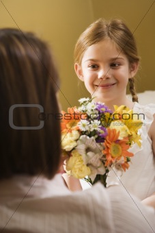 Girl giving mom flowers.