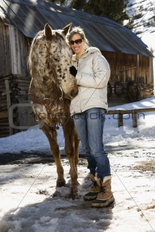 Woman petting horse.
