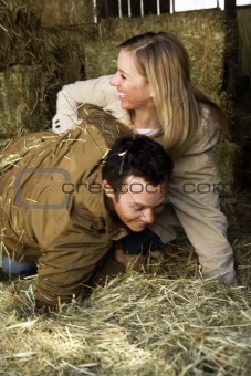 Couple playing in hay.