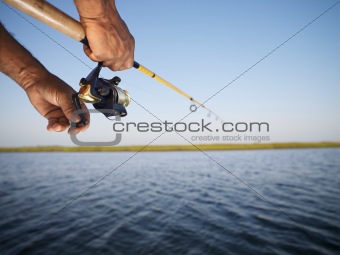 Hands holding fishing pole.