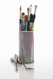 Paintbrushes in a metal mesh holder