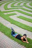 Young Woman Talking on the Phone in a Grass Maze