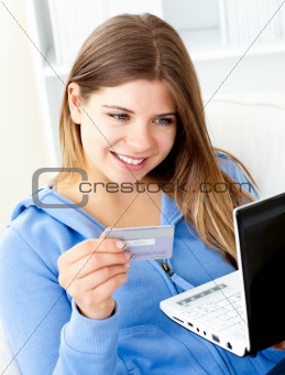 Happy woman with a credit card and a laptop