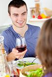 Handsome young man having diner with his girlfriend drinking wine