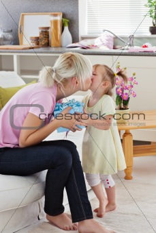 Cute little girl giving he mother a present 
