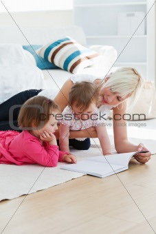 Positive young family reading a book on the floor 