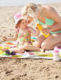 Attentive mother at the beach with her daughter 