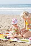 Little girl using suncream at the beach