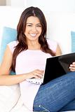 Bright asian woman using her laptop at home