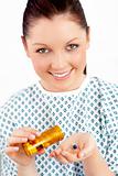 Smiling caucasian female patient holding pills