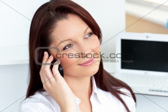 Cheerful businesswoman talking on phone sitting