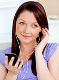Attractive woman using her cellphone to listen to music with ear