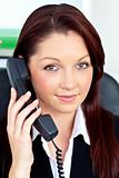 Positive businesswoman phoning in her office