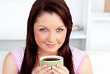 Portrait of an attractive woman holding a cup of coffee at home 
