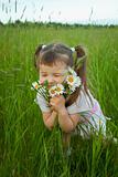 Little girl embraces flowers - chamomiles