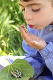 little girl palying with silkworm in hands