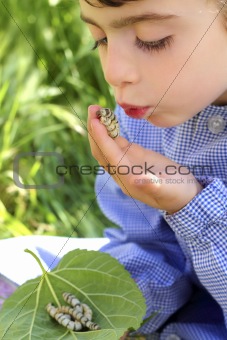 little girl palying with silkworm in hands