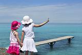 two girls tourist turquoise sea goodbye hand gesture