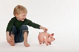 Young Boy Saving Money in a Coin Bank