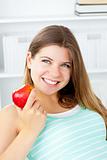Smiling young woman holding an apple in her hand
