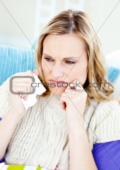 Downcast woman lying on a sofa with tissues