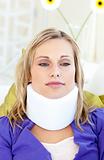 Attractive woman wearing neckbrace lying on a sofa