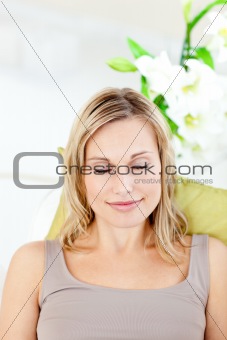 Relaxed young woman with closed eyes lying on a sofa