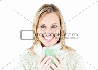 Smiling blond woman wearing a pullover and holding a cup of coff