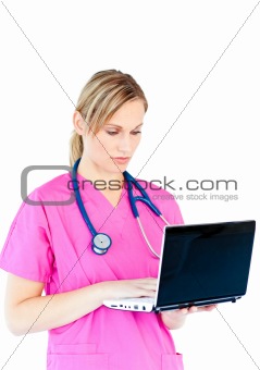 Concentrated female surgeon using a laptop
