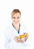 Charming young doctor holding pills smiling at the camera